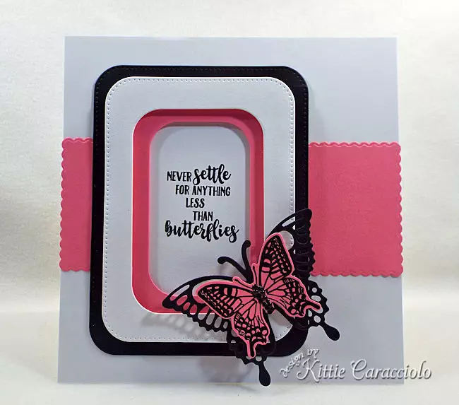 A pink and black die cut butterfly is pretty on a white clean and simple background.