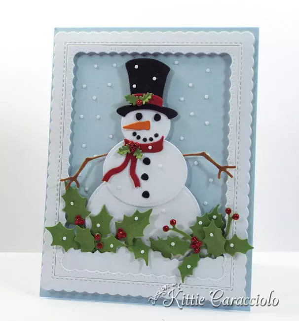 Come see how I made this die cut snowman scene with falling snow and holly.