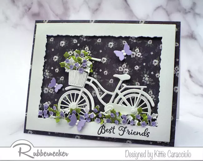 Click thru to check out how I made this white bicycle silhouette scene card with a pretty designer paper background and paper flowers. 
