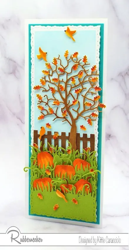 A vertical slimline fall card featuring a tall tree with shaped leaves and a pumpkin patch all created using die cuts
