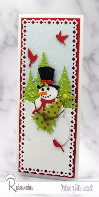 one of my snowman Christmas cards with a die cut snowman holding a Christmas tree in a snowy scene on a slimline card