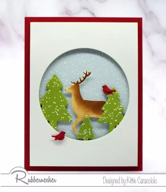 This Snowy Winter Scene with the buck and cardinals posing in the falling snow was made using die cuts from Rubbernecker