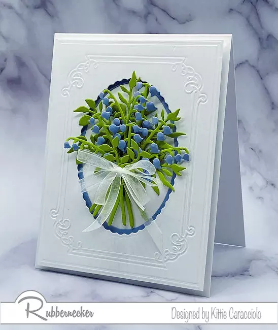 a simple flower bouquet card gets elevated by the use of a mass of the same die cut flowers against a white on white embossed background