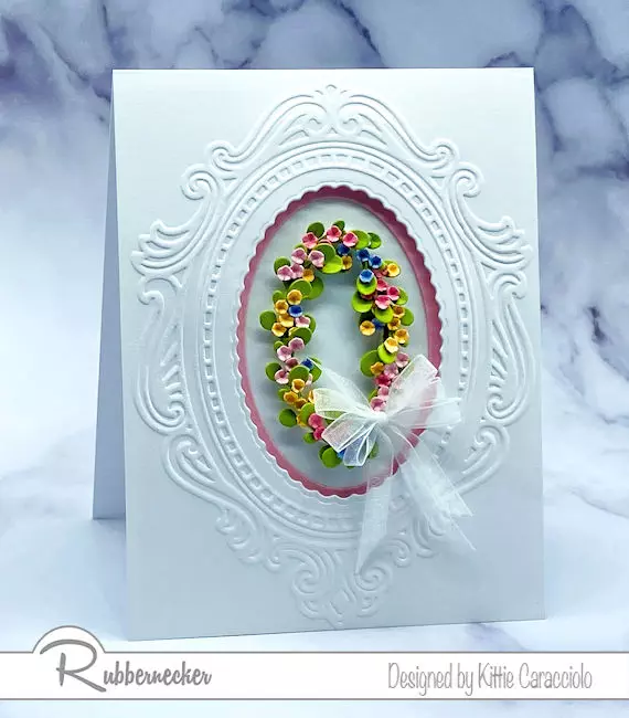 a handmade greeting card featuring a tiny oval wreath of flowers made entirely from die cut leftovers
