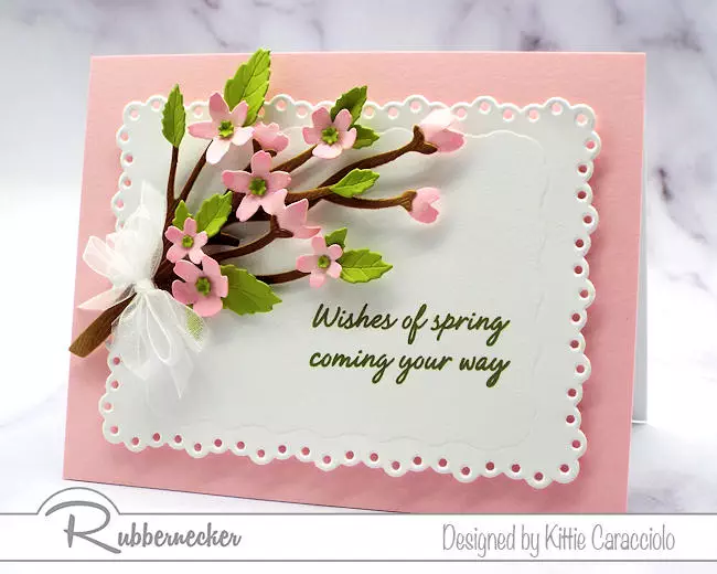 a delicate die cut cherry blossom bouquet adorning a handmade greeting card in pink and white