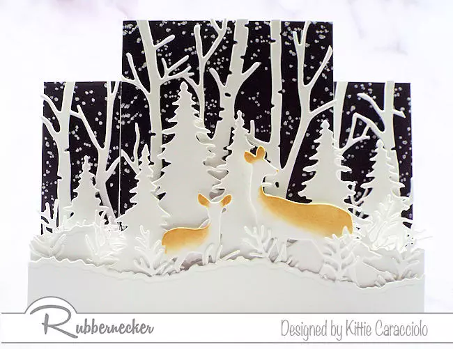 An all white scene of birch trees and deer set on on dramatic black background on a handmade winter center step card.