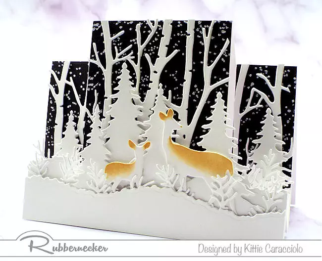 A winter center step card depicting deer in a pure white birch forest made with a premade card base and easy to use dies.
