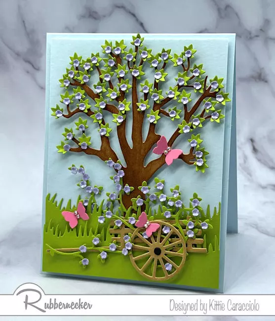 A pretty handmade flowering tree card mad with dies for the trunk, blossoms and garden details.