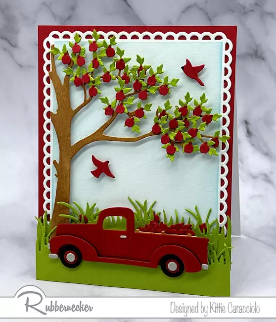 On of my handmade apple season cards with a tree loaded with fruit ready to be loaded into the iconic red pickup truck all made with dies from Rubbernecker.