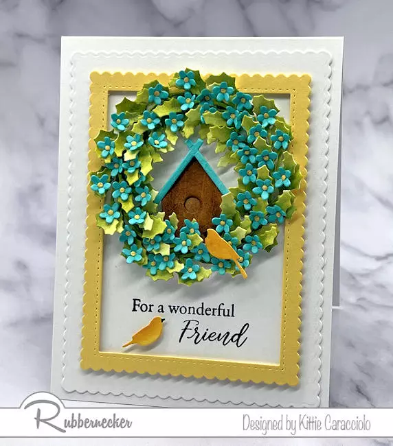 A pretty die cut summer wreath card with a lush wreath made using just two dies with a tiny birdhouse tucked inside.