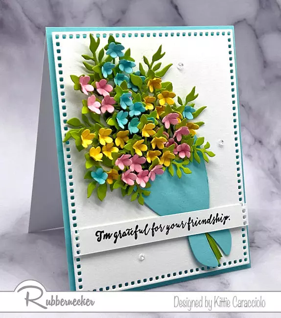 Lots of tiny paper flowers, in many colors and shaped for dimension, make the wrapped bouquet on a handmade card extra luxurious and perfect for all occasions.
