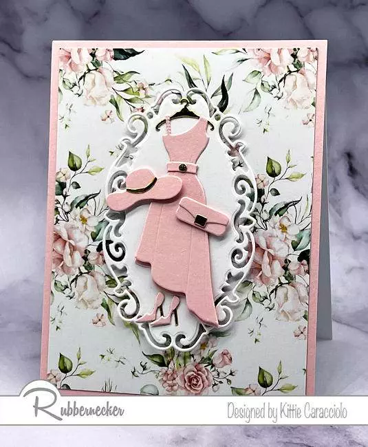 An elegant feminine handmade card idea made with a die cut dress and accessories set over patterned paper all in shades of pink and gold.