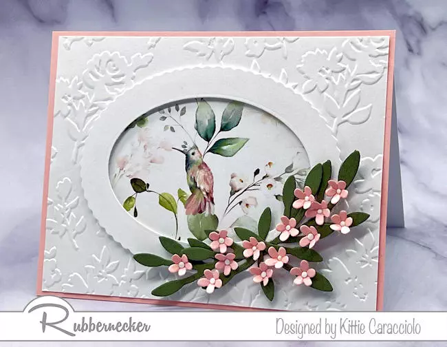 How to highlight a patterned paper is perfectly illustrated on this handmade card with a hummingbird centered in a die cut frame.