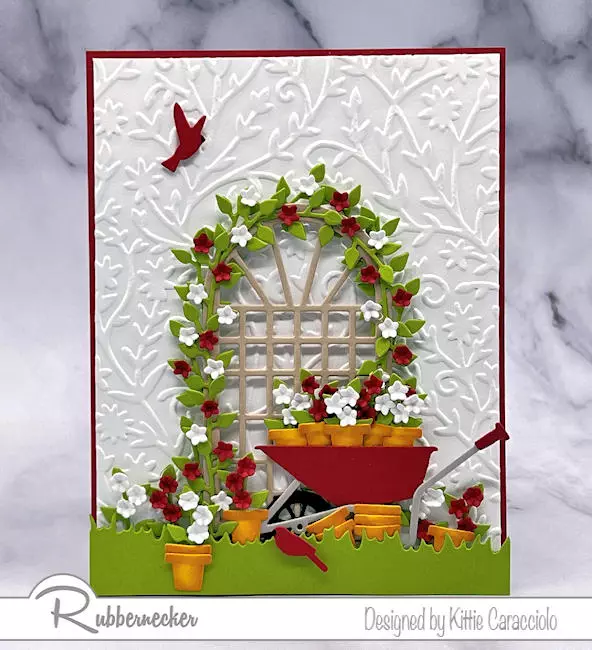 An arched trellis loaded with flowers and a precious wheelbarrow full of pots - all made from die cuts - make up this design for beautiful handmade cards for gardeners.
