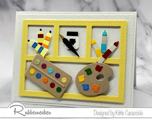 A cute handmade card for an artist with a variety of die cut and hand colored artist tools arranged in a multi window frame.