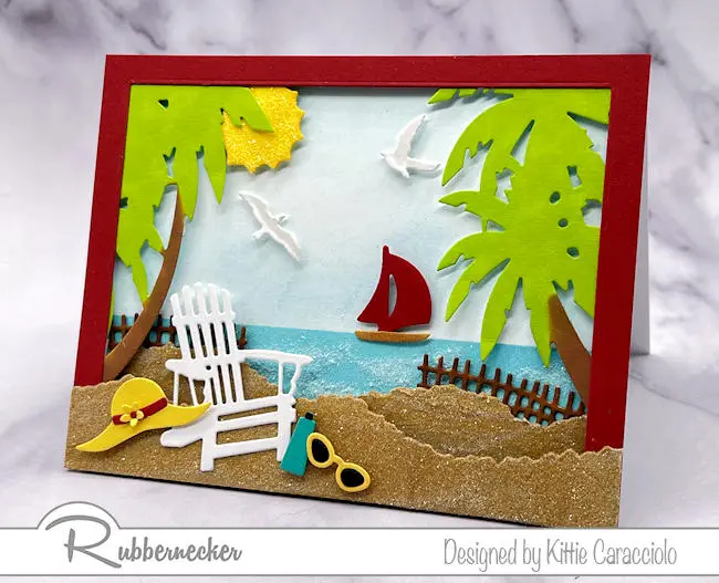 A detailed handmade beach scene card made using die cuts and some clever tricks to add texture to the sand and ocean.