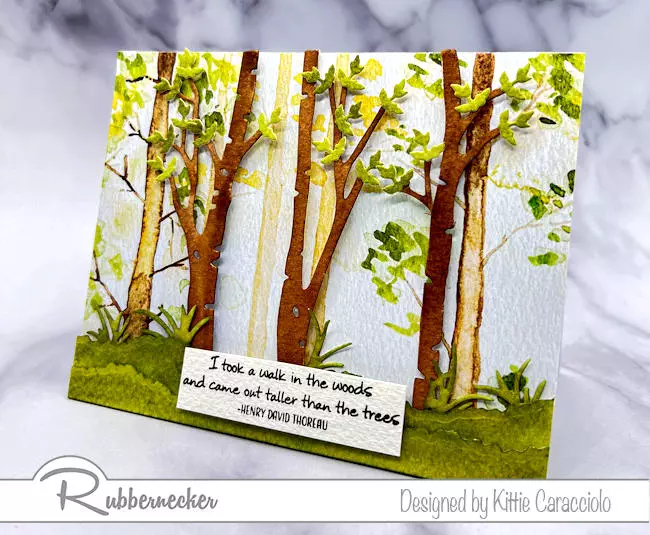 A beautiful hand painted looking card using a sheet of paper from the Rubbernecker Scenic Route Paper Pad with die cuts arranged over it to create a pretty, welcoming scene.