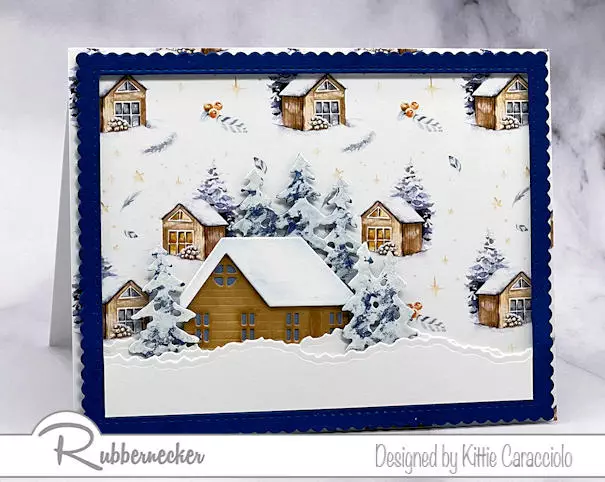 One of my handmade cozy winter cards depicting a charming little cabin set in a snowy scene backed with a patterned paper that accents the elements perfectly.