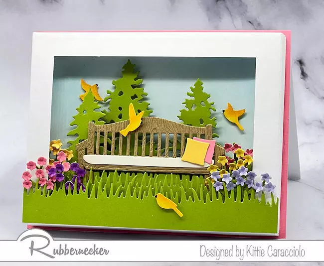 A summer scene greeting card idea with a bench set in a beautiful colorful landscape all made from dies from Rubbernecker.