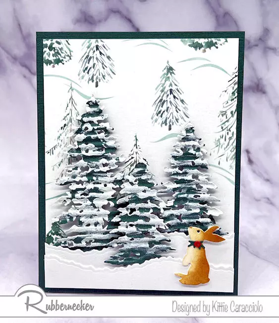 If you need a quick project to make this easy winter snowy scene card comes together in no time and uses fast die cuts and patterned paper from Rubbernecker for a seasonal theme.