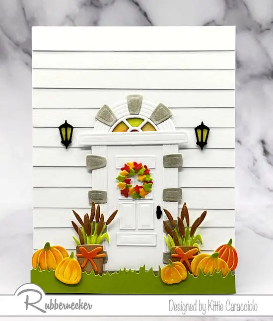 Sweet little pumpkins and fall foliate decorate this charming fall door card made with die cuts, all from Rubbernecker.