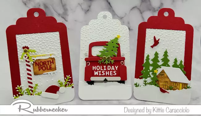 Learn how to make die cut frame Christmas tags like this trio of winter and holiday scenes all made with dies from Rubbernecker to make the North Pole sign, the classic red pickup truck and the tiny winter cabin.