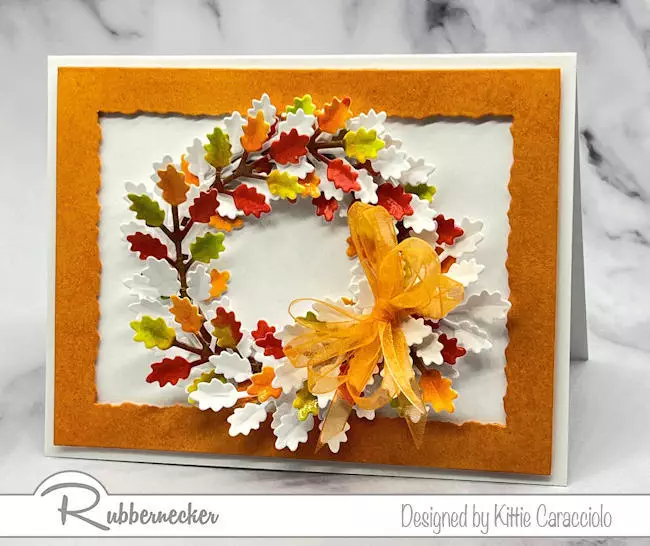 A handmade autumn leaf wreath card made with layering white and hand colored die cut sprigs.