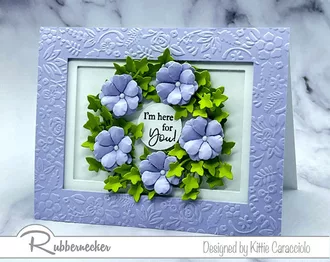 A wreath of die cut paper flowers in a lovely lilac are the only decoration needed on this handmade all occasion greeting card.